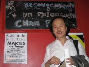 Chan Park standing at El Beso milonga during a special recognition night, surrounded by a supportive tango community in Buenos Aires.