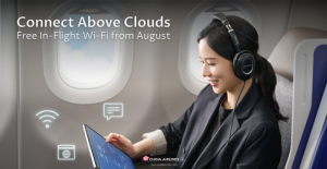 A woman in business class using a tablet with headphones on, smiling while connected to in-flight Wi-Fi. Icons for internet, messaging, and browsing float around her. Text on image reads: "Connect Above Clouds – Free In-Flight Wi-Fi from August." China Ai
