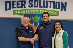 Deer Solution of North Austin owner Chuck Greene shakes hands with co-founders Kris and Jaime Goodrich