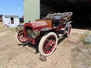 1909 REO maroon motor car company Model D toy tonneau car. Older restore. 4-seater. Wood spoke rims. Black leather seating. 4 cylinder 30hp motor and chain drive. The lamps are there.