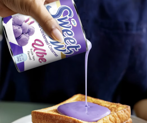Close-up of Sweet Cow Ube Sweetened Condensed Creamer being spread on toast, highlighting its smooth texture and vibrant purple color.