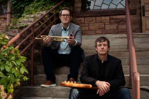 Matt Skellenger with his Electric Bass and Matt Reid with his Trumpet sitting on stairs