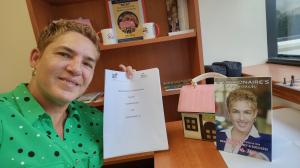 Martha Pino, Co-Founder of Viamar Homes, in her office, holding the MoU between Viamar Homes and The Trueness Project. Photo: Martha Pino.