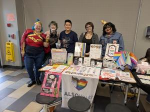 ALSO Youth staff and youth at SSAS Toracon with Pride flags and flyers promoting their upcoming Space Cowboy-themed prom.