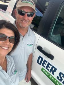 Mark and Vicki Snyder proudly stand in front of their Deer Solution vehicle.