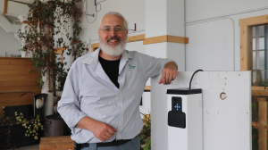 Ryan Hunt stands beside a prototype HUG Mini system