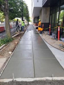 Concrete contractors working on a city sidewalk in Portland, Oregon