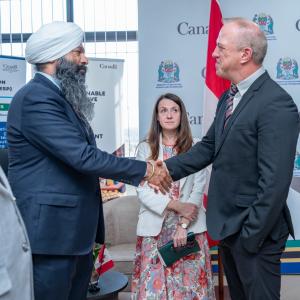 The Honorable Sandeep Sarai, Secretary of State international development shakes hands with FINCA Canada Executive Director Drew Boshell while Canadian High Commissioner of Tanzania Emily Burns looks on.