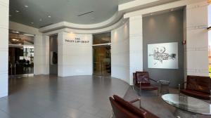 Interior view of The Valley Law Group office lobby with leather chairs, a glass table, and wall signage in a sleek, modern setting.