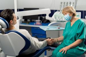 Dentist and patient happily shake hands after discussing flexible dental payment options.