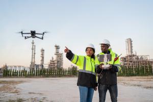 Two engineers are deploying a drone for construction site mapping.
