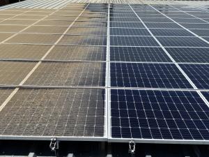 Side-by-side view of a solar panel with one half dirty and the other half professionally cleaned in Visalia, CA by Superior Solar Cleaners