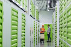 Two people shake hands inside a temperature-controlled storage facility, symbolizing agreement on secure storage services