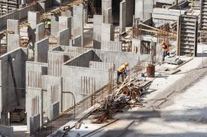 Concrete construction underway for apartment buildings in a densely developed urban area.
