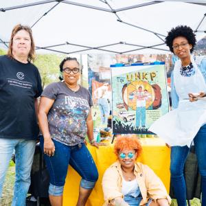 Artists painting the Paul “Unk P” Gripper mural during the community paint day, organized by Mural Arts.