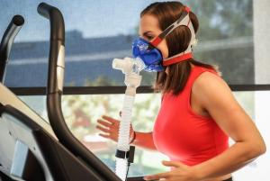 Woman on a treadmill running with a vo2 mask on to check her Vo2Max for longevity