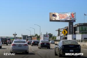 A traffic on a freeway with Christmas in July billboard.