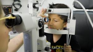 A child receiving an eye exam at TSO Champions, a Houston eye doctor emphasizing back-to-school eye exams.