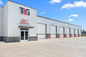 Peterbilt dealership with TLG Parts & Service Sign and service bay doors that are closed.