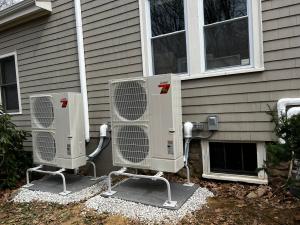Mitsubishi Hyper-Heat heat pump condensers installed outside a Massachusetts home for whole-home heating and cooling under the Mass Save rebate program.