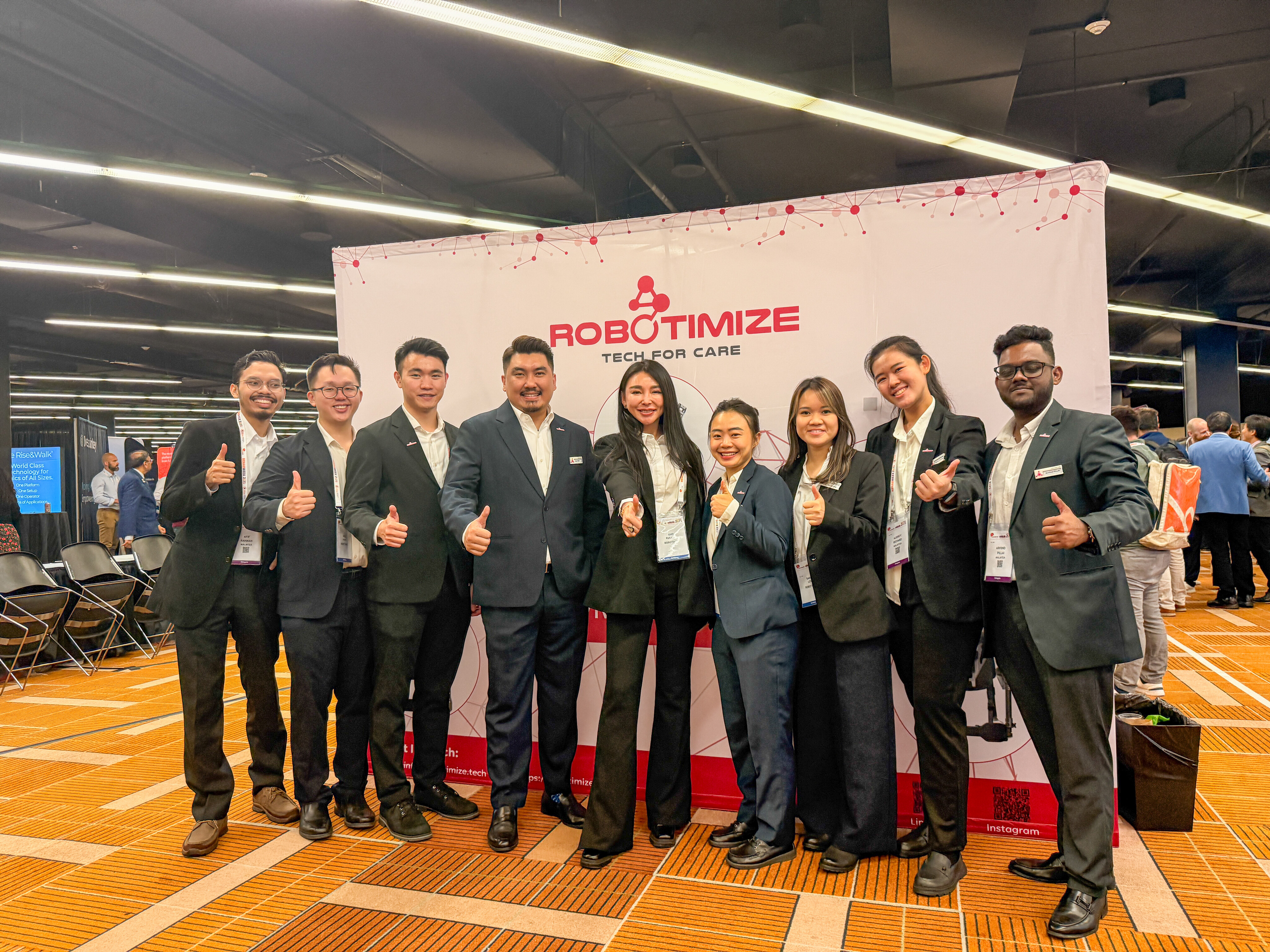 The Robotimize team, with CEO and Founder Kerry Guo, standing at their exhibition booth during RehabWeek 2025 in Chicago, showcasing advanced VivantePlexus™ rehabilitation technologies.