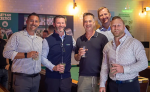 From left to right: Dave Mulcahey, Vice President of Sales, Steve Mumm, Chief Commercial Offer, Yeghian, Dustin Snavely, Vice President of National Sales, and Adam Yunker Vice President of Commercial Operations standing together holding drinks. A 'Let's G