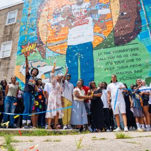 Confetti fills the air as the Unk P mural designed by Nile Livingston is officially unveiled on Ridge Avenue with family friends Councilmembers Isaiah Thomas and Jeffery Young Jr and North Philly community members