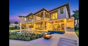 Luxury backyard with infinity spa, saltwater pool, LED lighting, outdoor kitchen, fireplace, yacht dockage, and wood-finish details at 51 Isla Bahia Drive in Fort Lauderdale.