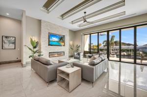 This contemporary Cape Coral residence is complete with a fireplace, modern furnishings and floor-to-ceiling glass doors overlooking a waterfront pool and tropical landscape.