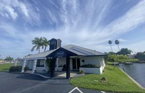 An exterior view of John R. Wood Christie’s International Real Estate's Cape Coral office, located on the Plato Canal with direct water access and modern spaces for up to 24 agents.
