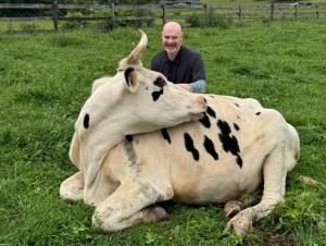 Jacob with Anya, a Holstein cow rescued from a dairy farm in 2022.