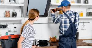 back view of handyman with drill repairing.