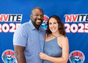 photo of husband and wife standing in front of a DonutNV background at the annual franchise conference