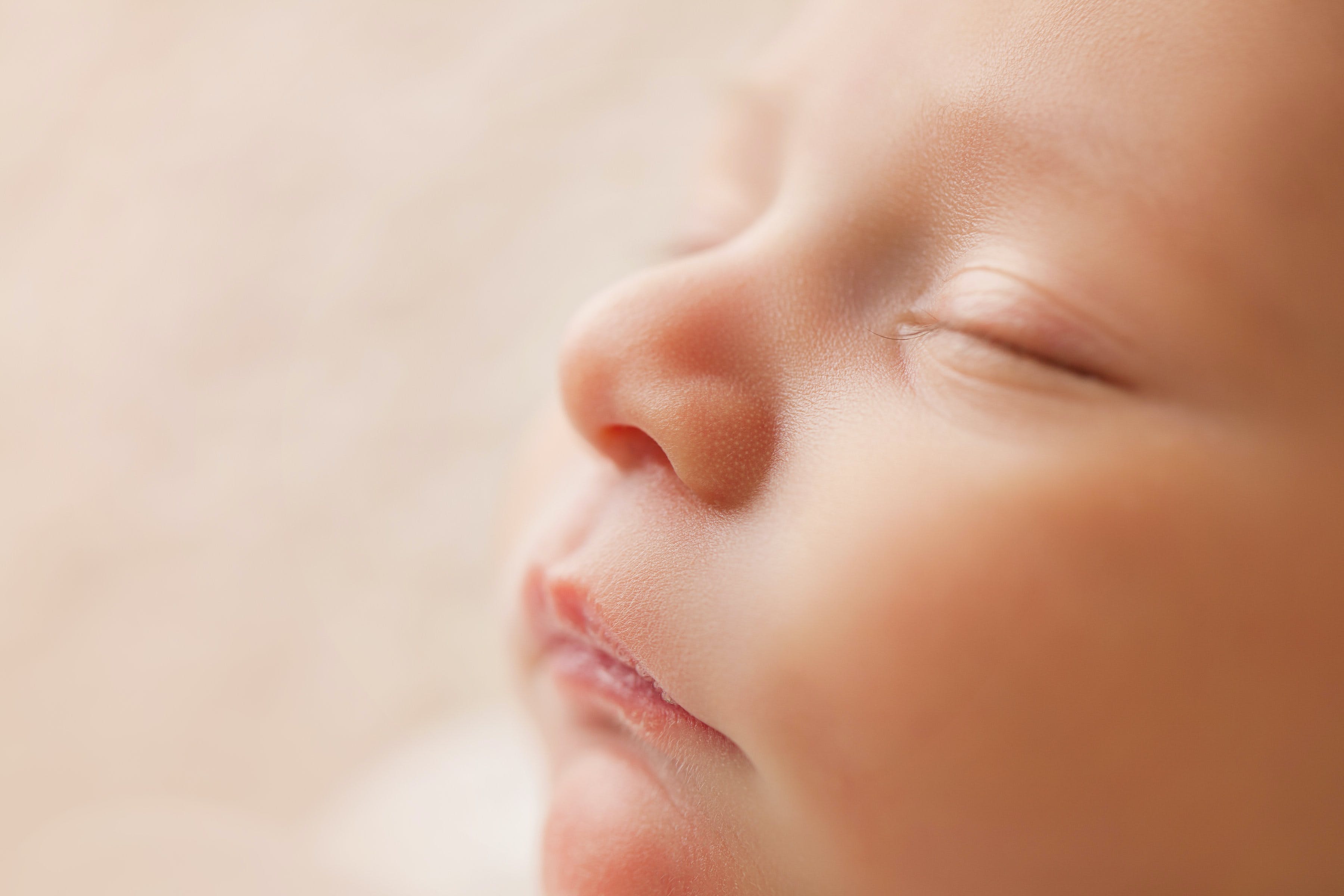 We see a close up of a sleeping newborn baby