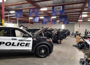A photo of a Dana Safety Supply emergency vehicle upfit shop, showing Technicians working on police vehicles.