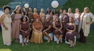 The clinical and administrative staff of Birth Detroit stand together for a group picture with various shades of brown, smiling.