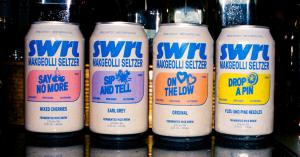 Four cans of SWRL makgeolli seltzer lined up at a bar, featuring flavors Mixed Cherries, Earl Grey, Original, and Yuzu with Pine Needles.