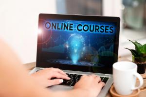 person holding a lap top computer on the screen an image saying Online Courses