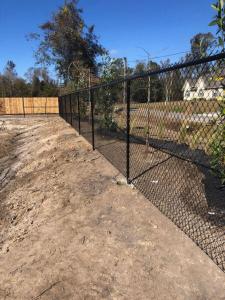 Commercial chain link and ornamental iron fence surrounding a business property in Southeast Louisiana, installed by Tony’s Fencing and Iron Works.