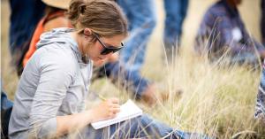 Soil Health Academy student taking notes afield.