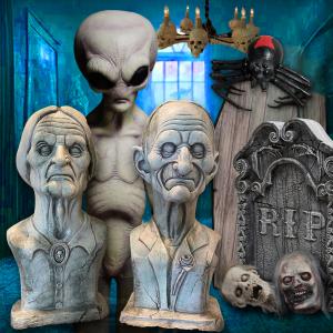Creepy Halloween display with alien figure, RIP tombstone, bust statues, skulls, and giant black spider.
