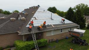 Roofer replacing a shingle roof