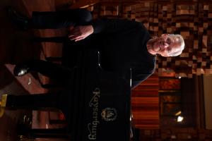 Ed Bazel, tall with white hair, dressed in black, sits at the piano in a darkened recording studio at Skywalker Sound