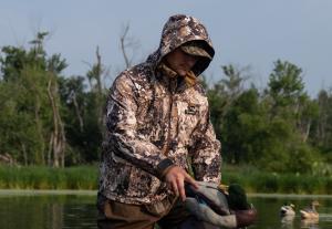 A man standing in the pond and placing the decoy