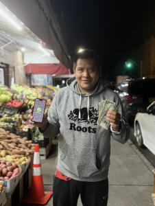 Secret World user holding cash and the app, demonstrating how the patented global platform helps independents earn through the task feature.