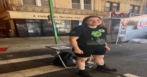 Photo of a woman hired on the Secret World app to work at the annual Bensonhurst Feast in Brooklyn, New York. She wears a Secret World T-shirt while promoting the platform, representing how the app connects people to real jobs and income opportunities in 
