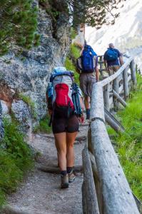 Alta Via 1 self guided hike in the Dolomites – hiker on AV1 trek with Dolomites hut booking along the trail.