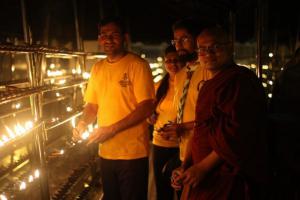 Volunteer Ministers join Buddhist monks in Sri Lanka in lighting candles for peace.