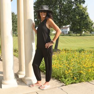 Barbara wearing the YOGAZ Signature Black pants paired with the Black Bow Top, featuring eco-friendly fabric, tummy-control front, relaxed fit pants with wide cuffs, and a stylish tied bow detail on the top