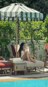Antonella Attorre spotted relaxing poolside at Island Shangri-La Hong Kong under a striped parasol